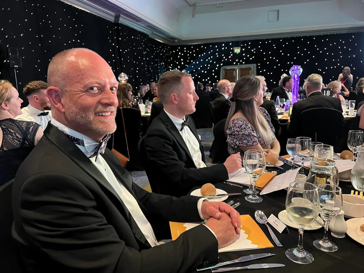 Colleagues having a conversation at a formal dinner event